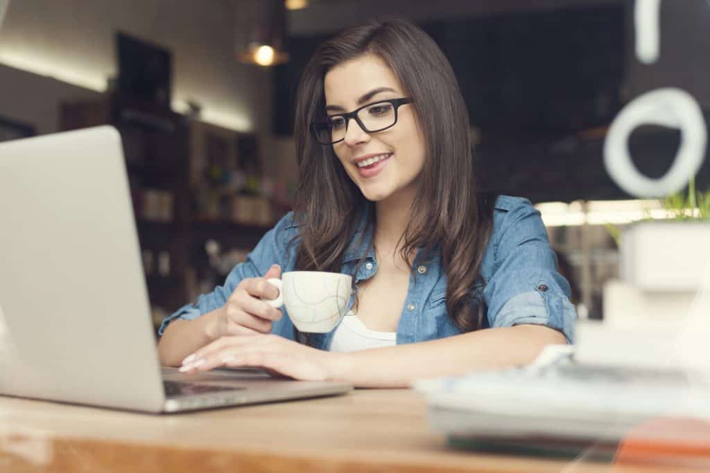 A woman sitting at a table using a laptop computer